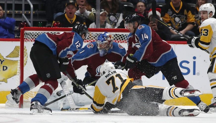 Pittsburgh Penguins center Evgeni Malkin, front, of Russia, tumbles to the ice as his shot is stopped by Colorado Avalanche goalie Semyon Varlamov, of Russia, back center, as defenseman Patrik Nemeth, ...