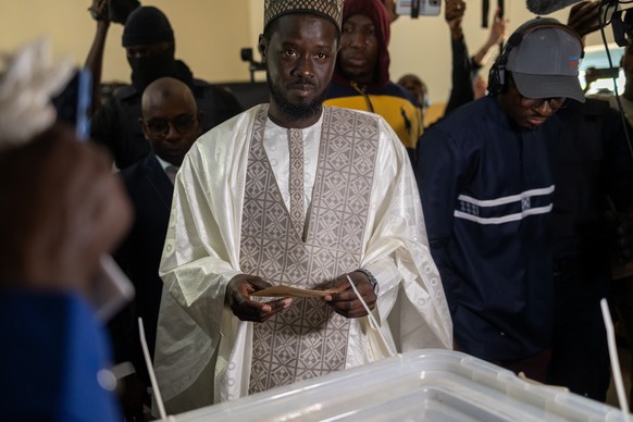 epa11241365 Opposition presidential candidate Bassirou Diomaye Faye (C) prepares to cast his vote for the presidential elections in Ndiaganiao, Thies Region, Senegal, 24 March 2024. The Senegalese are ...