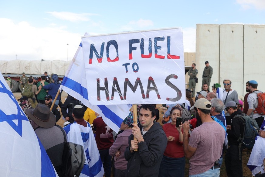epa11112162 Right-wing Israeli protesters try to block the road as aid trucks enter the Gaza Strip at the Kerem Shalom border crossing, southern Israel, January 29, 2024. Since October 7, 2024…