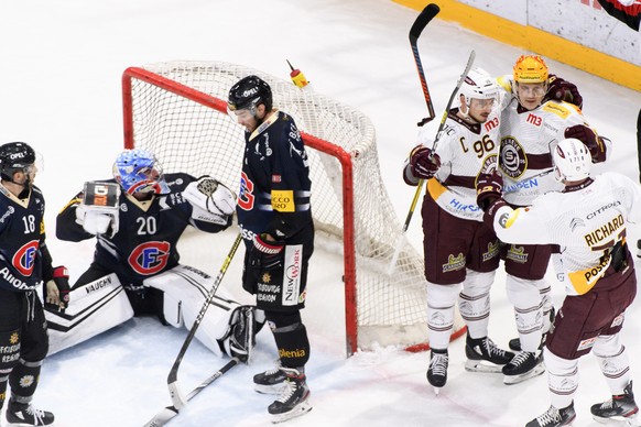 De gauche a droite, le defenseur fribourgeois Ryan Gunderson, le gardien Fribourgeois Reto Berra et le defenseur fribourgeois Benjamin Chavaillaz montrent leur deception a cote de la joie de lÕattaqua ...