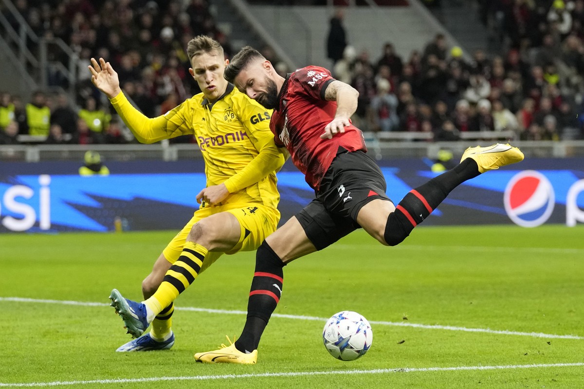 AC Milan's Olivier Giroud, right, challenges for the ball with Dortmund's Nico Schlotterbeck during the Champions League group F soccer match between AC Milan and Borussia Dortmund at the Sa ...