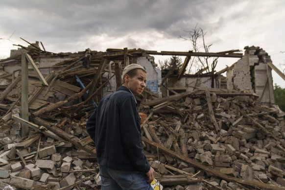 A resident looks at damaged homes from a rocket attack early this morning, Tuesday, Aug. 16, 2022, in Kramatorsk, eastern Ukraine, as Russian shelling continued to hit towns and villages in Donetsk pr ...