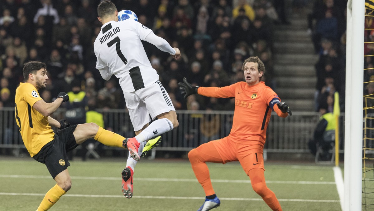 Juventus' Cristiano Ronaldo, center, tries a header against Young Boys' goalkeeper Marco Woelfli and Loris Benito, during the UEFA Champions League group stage group H matchday 6 soccer matc ...