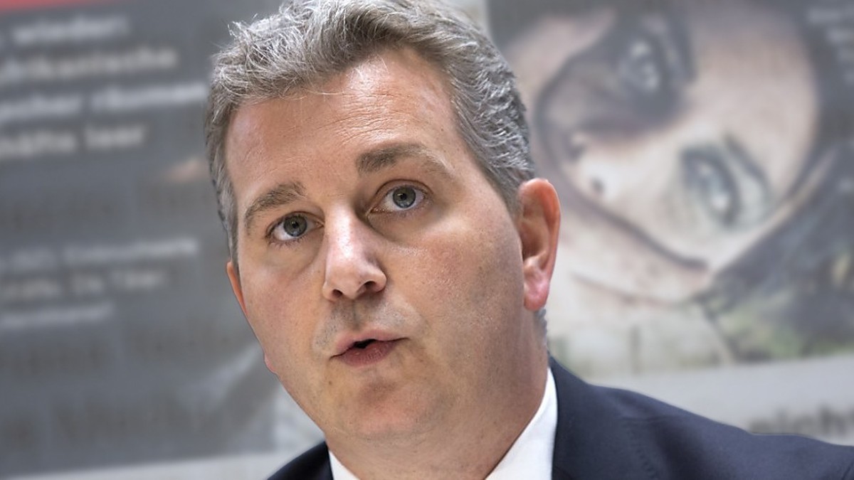 Marco Chiesa, président de l'UDC. En arrière-fond, l'un des visuels de campagne du parti identitaire.