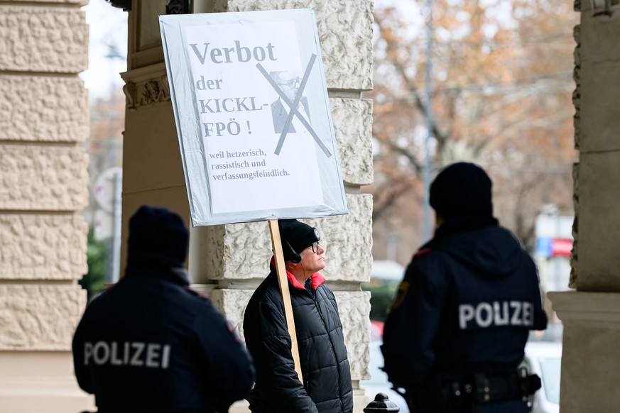 epa11811369 A man holds a placard reading &#039;Ban the Kickl-FPOe! Because agitational, racist, and hostile to the Constitution&#039;, in front of police outside the Freedom Party of Austria (FPOe) h ...