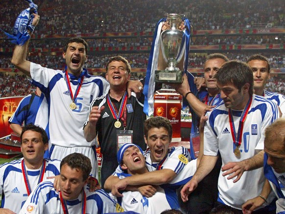 JAHRESRUECKBLICK 2004 - SPORT EURO - DIE GRIECHISCHE MANNSCHAFT IM FREUDENTAUMEL: Otto Rehhagel, second from left, the coach of Greece, celebrates with the team after beating Portugal 1-0 at the end o ...