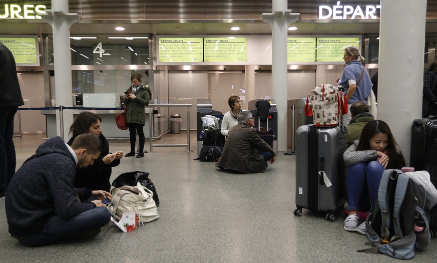 Travelers wait at St Pancras International train station in London, as Eurotunnel trains were suspended on Tuesday, Oct. 18, 2016. An electrical supply problem in the train tunnel beneath the English  ...