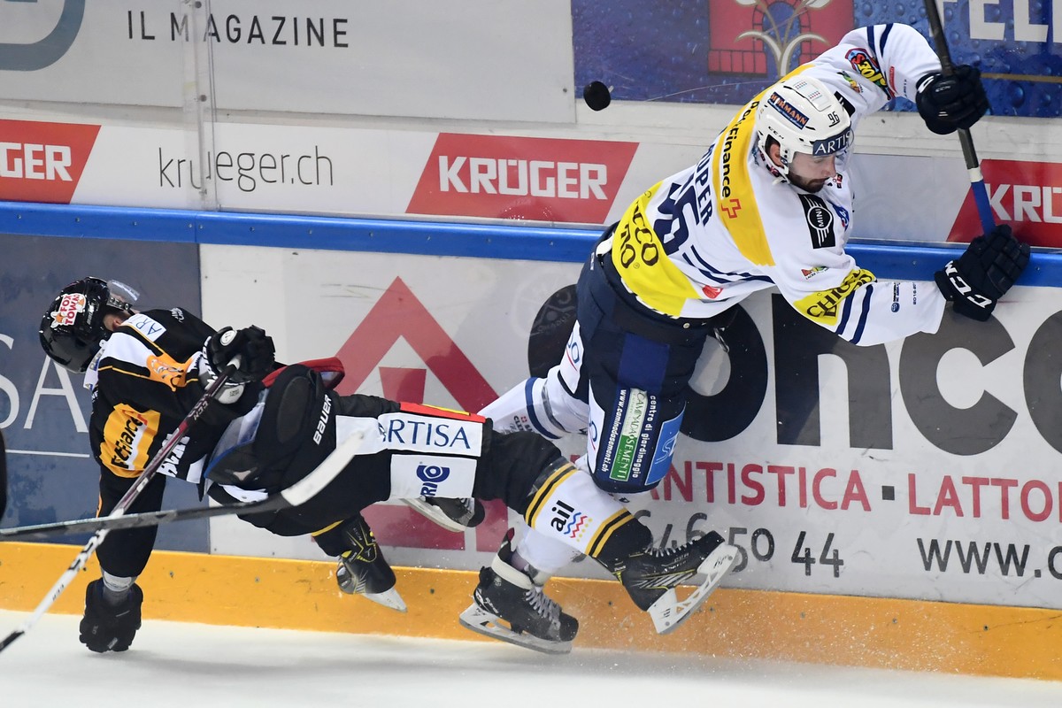 Lugano’s player Steve Hirschi, left, fights for the puck with Ambri's player Adrien Lauper, right, during the preliminary round game of National League A (NLA) Swiss Championship 2016/17 between  ...