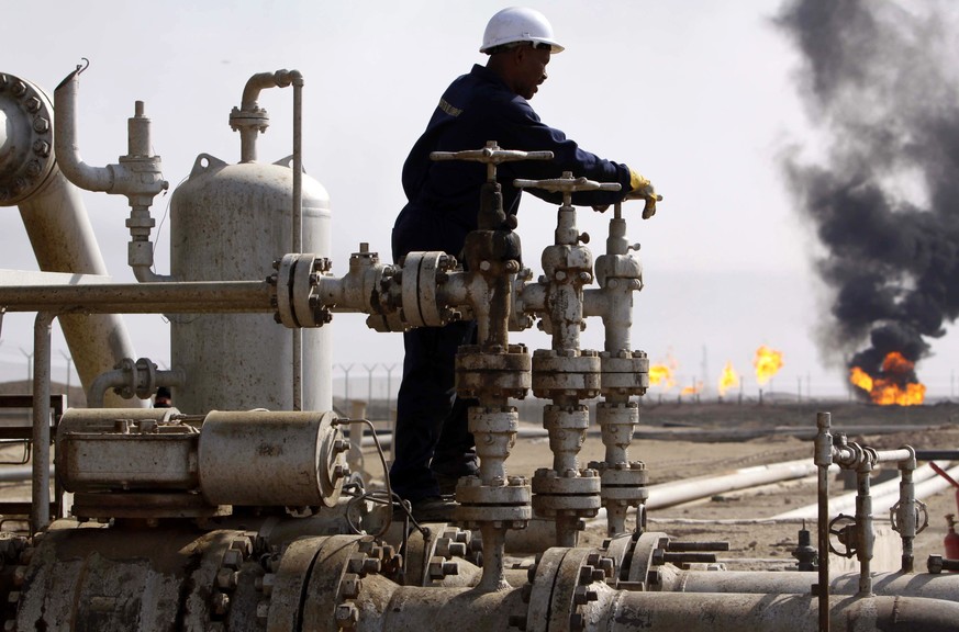 FILE - In this Monday, Nov. 9, 2009, file photo, an Iraqi worker operates valves at the Rumaila oil refinery, near the city of Basra, 550 kilometers (340 miles) southeast of Baghdad, Iraq. Iraq’s prim ...