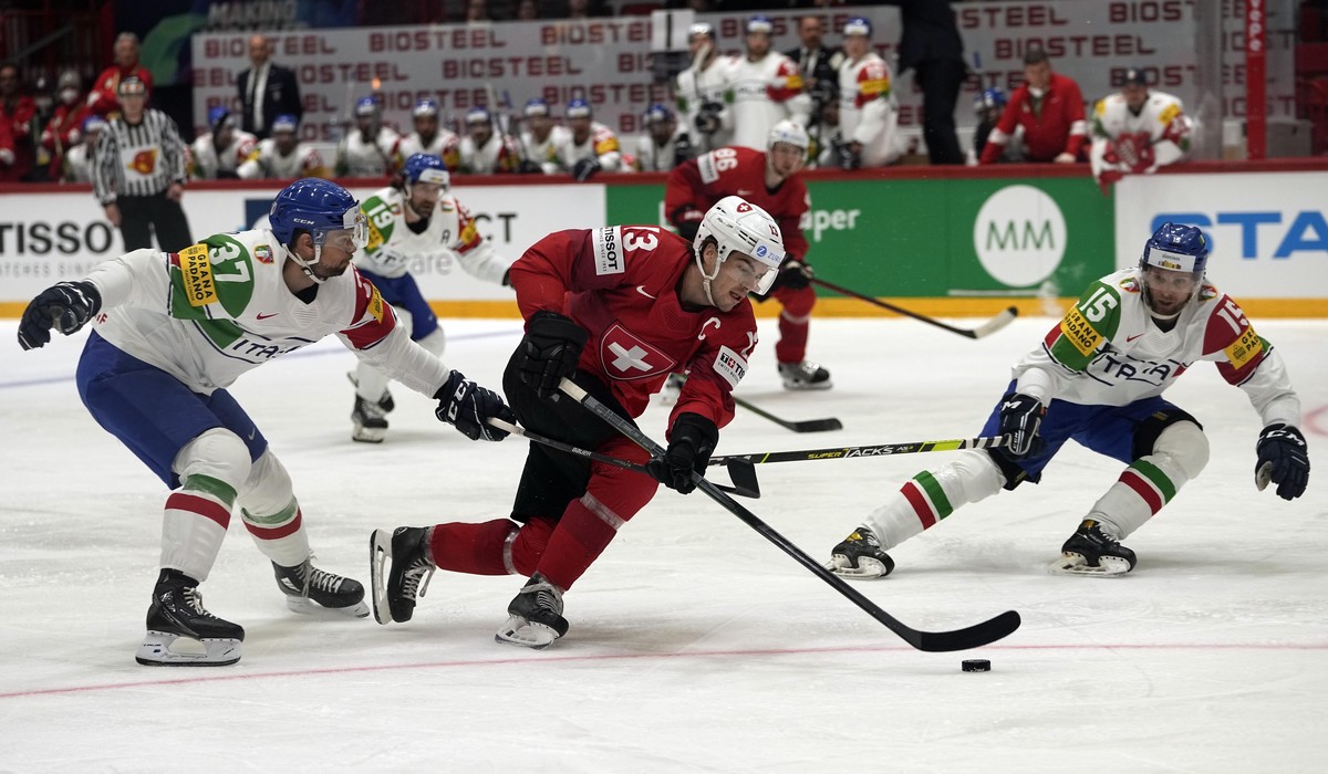 Nico Hischier of Switzerland, center, is challenged by Italy's Phil Pietroniro, left, during the group A Hockey World Championship match between Switzerland and Italy in Helsinki, Finland, Saturd ...