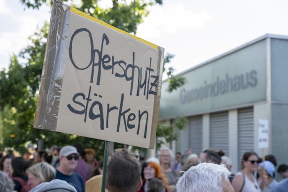 Teilnehmende bei einer Mahnwache gegen sexualisierte Gewalt halten Plakate hoch, am Montag, 27. Juli 2026 in Untersiggenthal. (KEYSTONE/Andreas Becker)