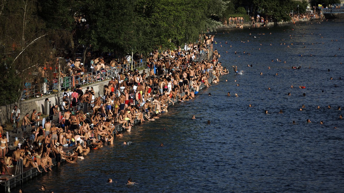 epa10020750 People take a bath in the river Limmat at Letten, as a heat wave reaches the country, in Zurich, Switzerland, 18 June 2022. EPA/MICHAEL BUHOLZER