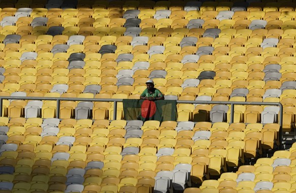 A supporter stands behind a Bangladesh flag during a qualifier match against Bahrain for the AFC Asian Cup 2023 held at the National Stadium Bukit Jalil in Kuala Lumpur, Malaysia on Wednesday, June 8, ...