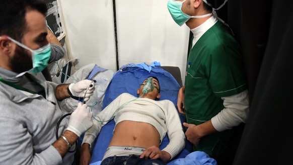 epa07188206 A handout photo made available by Syria’s Arab News Agency /SANA/ show medical staff treating people suffering suffocation symptoms at al-Razi hospital in the northern city of Aleppo, Syri ...