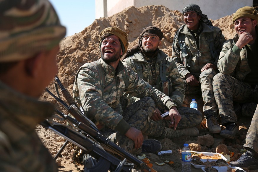 Syrian Democratic Forces (SDF) fighters gather as they have a meal in northern Deir al-Zor province ahead of an offensive against Islamic State militants, Syria February 21, 2017. REUTERS/Rodi Said