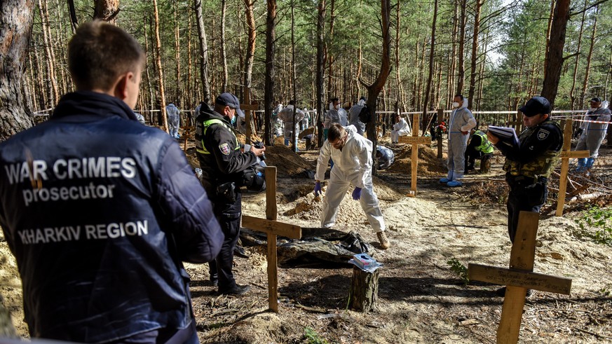 epa10199568 War crime prosecutor personnel during exhumation work on the cemetery in Izyum, Kharkiv region, Ukraine, 22 September 2022. The Ukrainian army pushed Russian troops from occupied territory ...