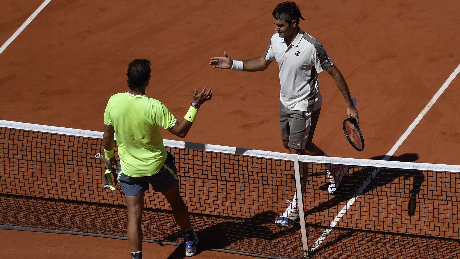 epa07632977 Rafael Nadal of Spain (L) reacts with Roger Federer of Switzerland after winning their men’s semi final match during the French Open tennis tournament at Roland Garros in Paris, France, 07 ...