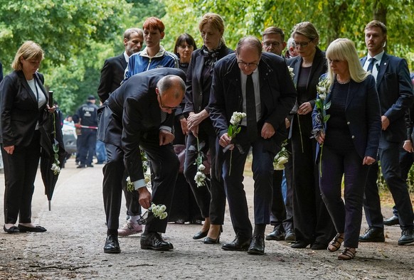 epa13134425 German Chancellor Friedrich Merz (L) and Federal Interior Minister Alexander Dobrindt (C) lay flowers as they visit the crime scene in Tiergarten park following a car-ramming attack near t ...