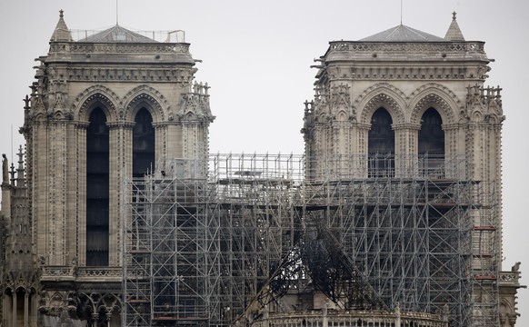 View of the scaffolding and damaged Notre Dame cathedral after the fire in Paris, Tuesday, April 16, 2019. Experts are assessing the blackened shell of Paris' iconic Notre Dame cathedral to establish next steps to save what remains after a devastating fire destroyed much of the almost 900-year-old building. With the fire that broke out Monday evening and quickly consumed the cathedral now under control, attention is turning to ensuring the structural integrity of the remaining building. (AP Photo/Christophe Ena)