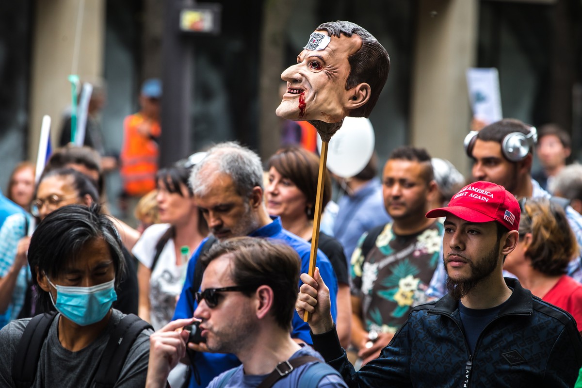 epa09423305 A protester carries a mask bearing the effigy of French President Emmanuel Macron planted on a pike during a demonstration held by right-wing party 'Les Patriotes' against the CO ...