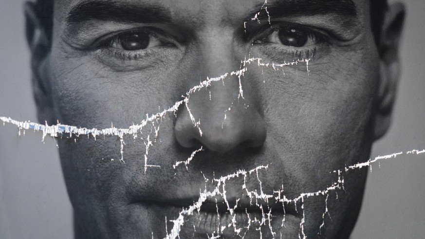FILE - A partially damaged poster of Spanish Prime Minister and Socialist Party candidate Pedro Sanchez flaps in Parla, outskirts Madrid, Spain, Friday, April 26, 2019. Most polling shows the conserva ...