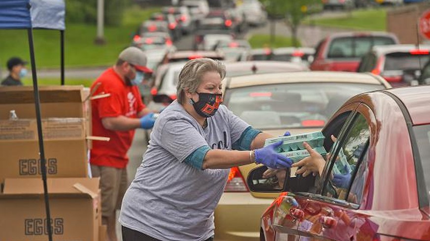 Cumru Twp, PA - May 23: Tracy Christmann, Sales Manager at Imperial Monuments in Shillington, gives a person in a car two dozen eggs during a free egg distribution at the Gov. Mifflin Intermediate Sch ...