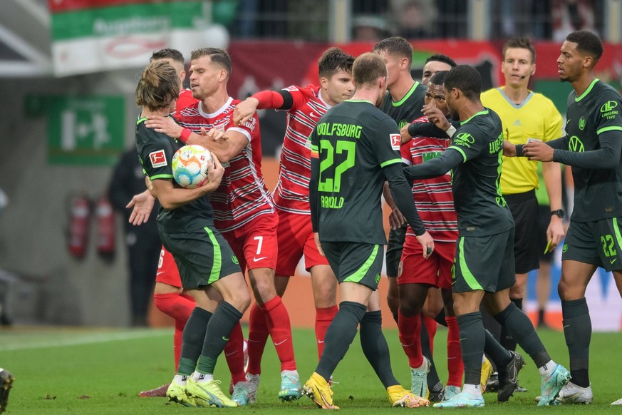 Fu�ball, 1. Bundesliga, 20221008, FC Augsburg - VfL Wolfsburg. Im Bild Florian NIEDERLECHNER FC Augsburg, 7 packt Patrick WIMMER VfL Wolfsburg, 39 am Hals. Augsburg WWK-Arena Bayern Deutschland *** So ...