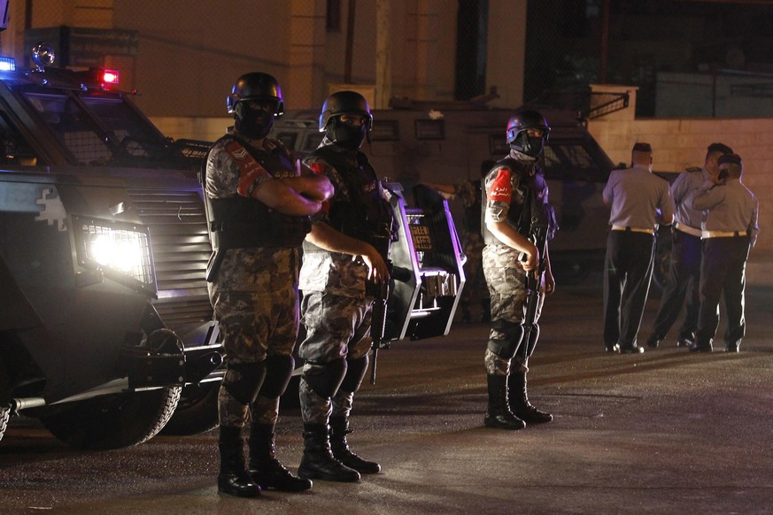 epaselect epa06105854 Jordanian security forces stand infront of their armored vehicle next to the Israel embassy, in Amman, Jordan, 23 July 2017. Media reports state that one person is dead and one i ...