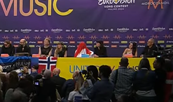 Joost Klein mit Flagge über dem Kopf.
