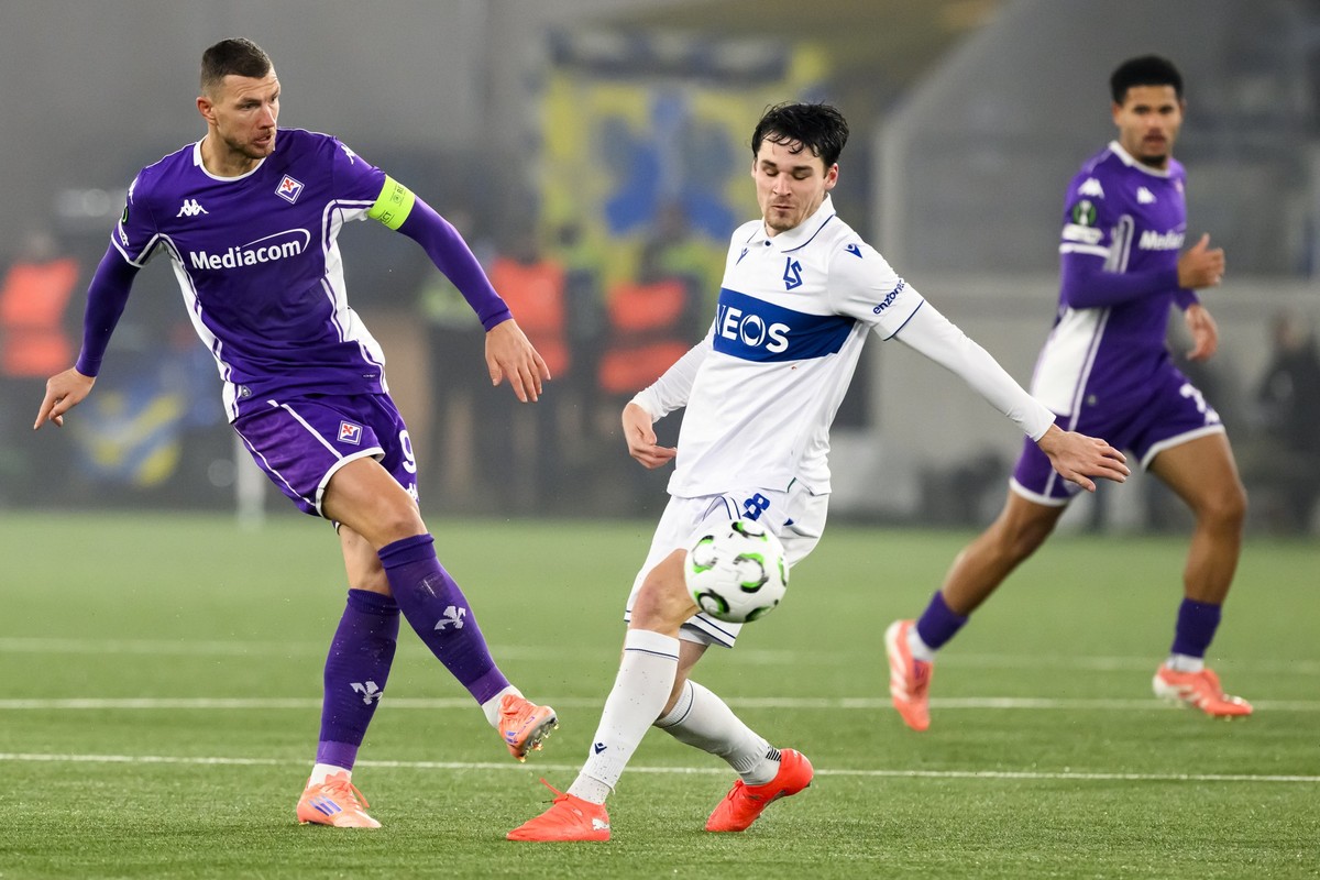 Fiorentina's Edin Dzeko, left, fights for the ball with FC Lausanne-Sport's Jamie Roche, right, during the League phase soccer matchday 6 of the UEFA Conference League between FC Lausanne-Sp ...