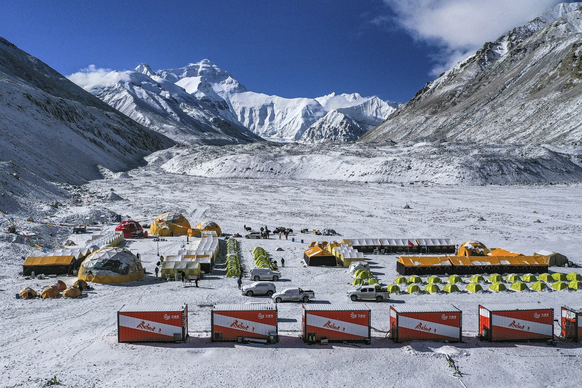 FILE - In this April 30, 2020, aerial file photo released by China's Xinhua News Agency, vehicles and tents are seen at the base camp at the foot of the Chinese side of the peak of Mount Qomolang ...