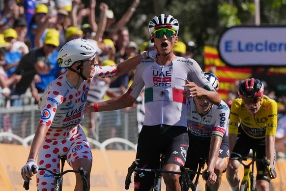 Mexico's Isaac Del Toro, right, celebrates with Slovenia's Tadej Pogacar as he crosses the finish line to win the second stage of the Tour de France cycling race with start in Tarragone and  ...