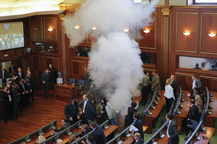 epa05170020 Opposition lawmakers throw tear gas during a plenary session at Kosovo's parliament in Pristina, Kosovo, 19 February 2016. Kosovo's opposition political parties protest demanding the resig ...