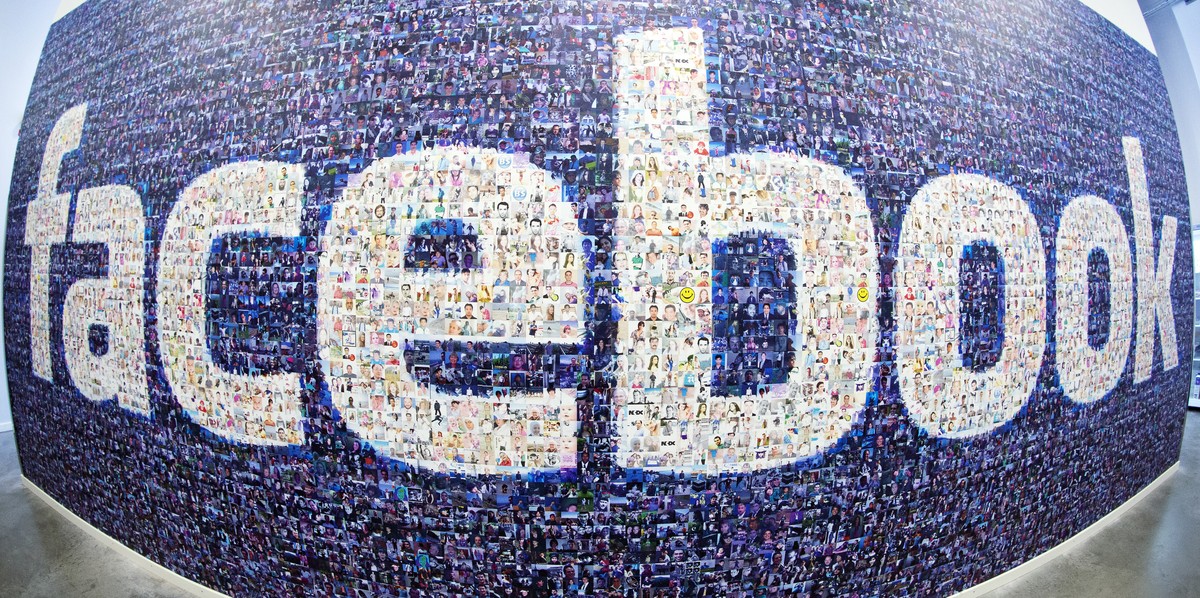 This picture taken with a fisheye lens shows a man walks past a big logo created from pictures of Facebook users worldwide in the company's Data Center, its first outside the US on November 7, 20 ...