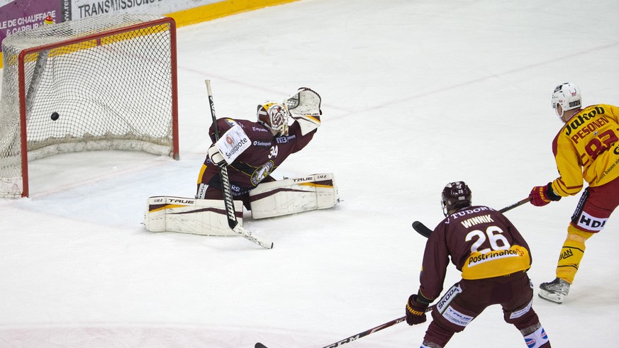 Tigers&#039; forward Harri Pesonen, of Finland, right, scores the 1:2 against Geneve-Servette&#039;s goaltender Gauthier Descloux, left, past Geneve-Servette&#039;s forward Daniel Winnik #26, of Canad ...