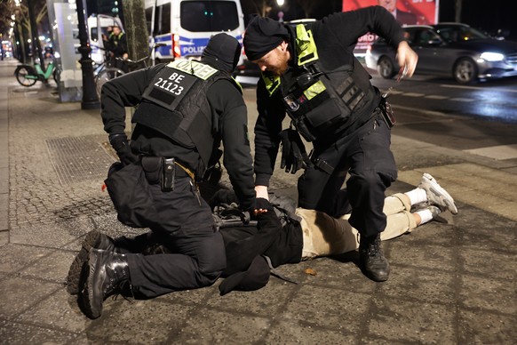 epaselect epa11913951 Police officers arrest a man near the Holocaust Memorial in Berlin, Germany, 21 February 2025, after another man was seriously injured with a sharp object. The injured man was ta ...