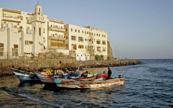 FILE - In this Wednesday, March 18, 2015, file photo, fishermen work on their boats in the southern city of Aden, Yemen. Hundreds of families are trapped in their homes by weeks of fierce fighting in  ...