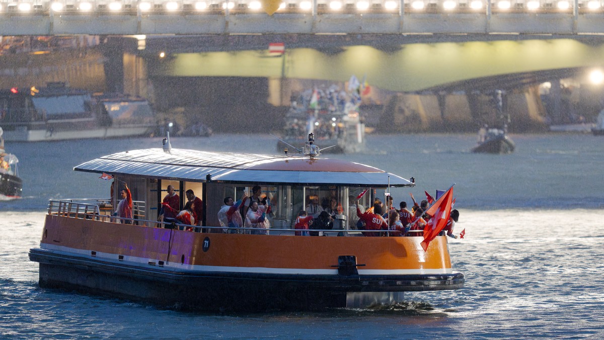 Switzerland's flag-bearers mountainbiker Nino Schurter and sports shooter Nina Christen celebrate with Swiss athletes on a boat at the opening ceremony of the 2024 Paris Summer Olympics on the Se ...