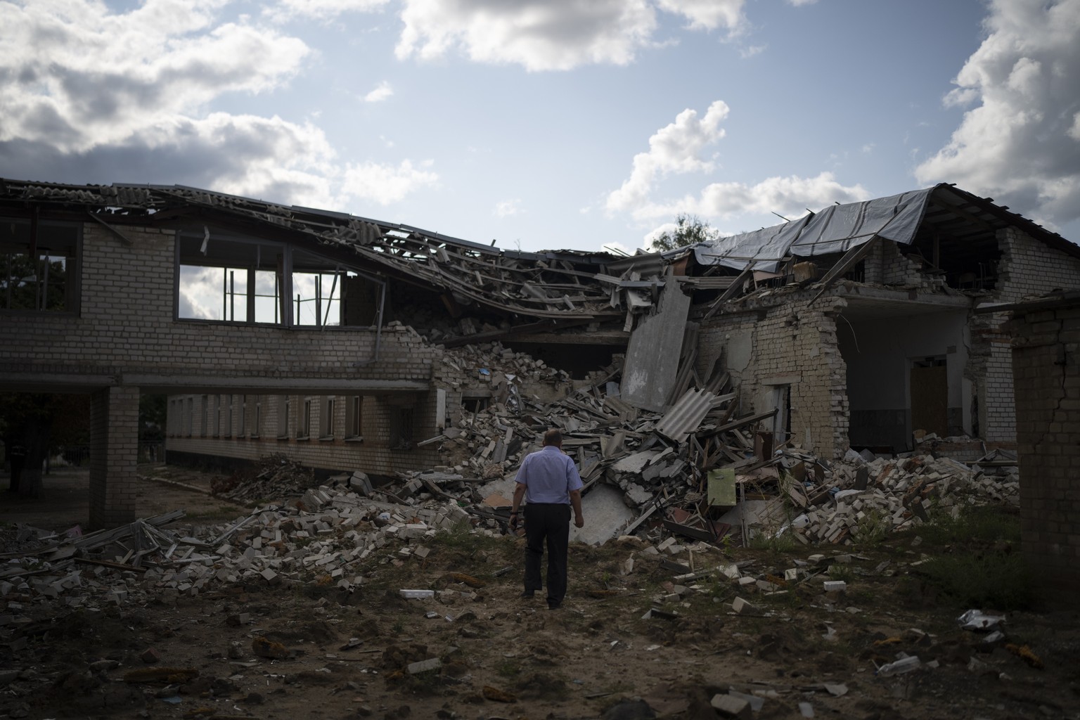 Oleksandr Pishchyk, a school director, stands in front of the school library that was destroyed by shelling in Kupiansk, Ukraine, Wednesday, Aug. 23, 2023. There are still 451 children in Kupiansk who ...