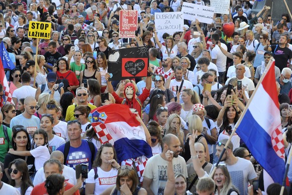 Protesters hold placards during a protest in central Zagreb, Croatia, Saturday, Sept. 5, 2020. Several thousand gathered to protest against government measures against spreading of the Covid-19 virus. ...