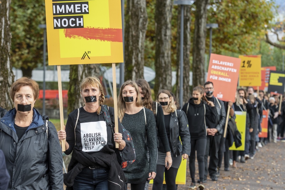 Demonstranten marschieren beim walk for Freedom in einer Einerkolonne gegen Menschenhandel und moderne Sklaverei bei einer Aktion am Samstag, 15. Oktober 2022 in Luzern. (KEYSTONE/Urs Flueeler)