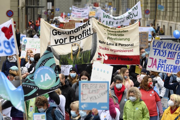 Personen protestieren waehrend einer Demonstration unter dem Moto &quot;Gemeinsam mit dem Gesundheitspersonal und Ja zur Pflegeinitiative&quot;, am Samstag, 30. Oktober 2021, in Bern. (KEYSTONE/Anthon ...