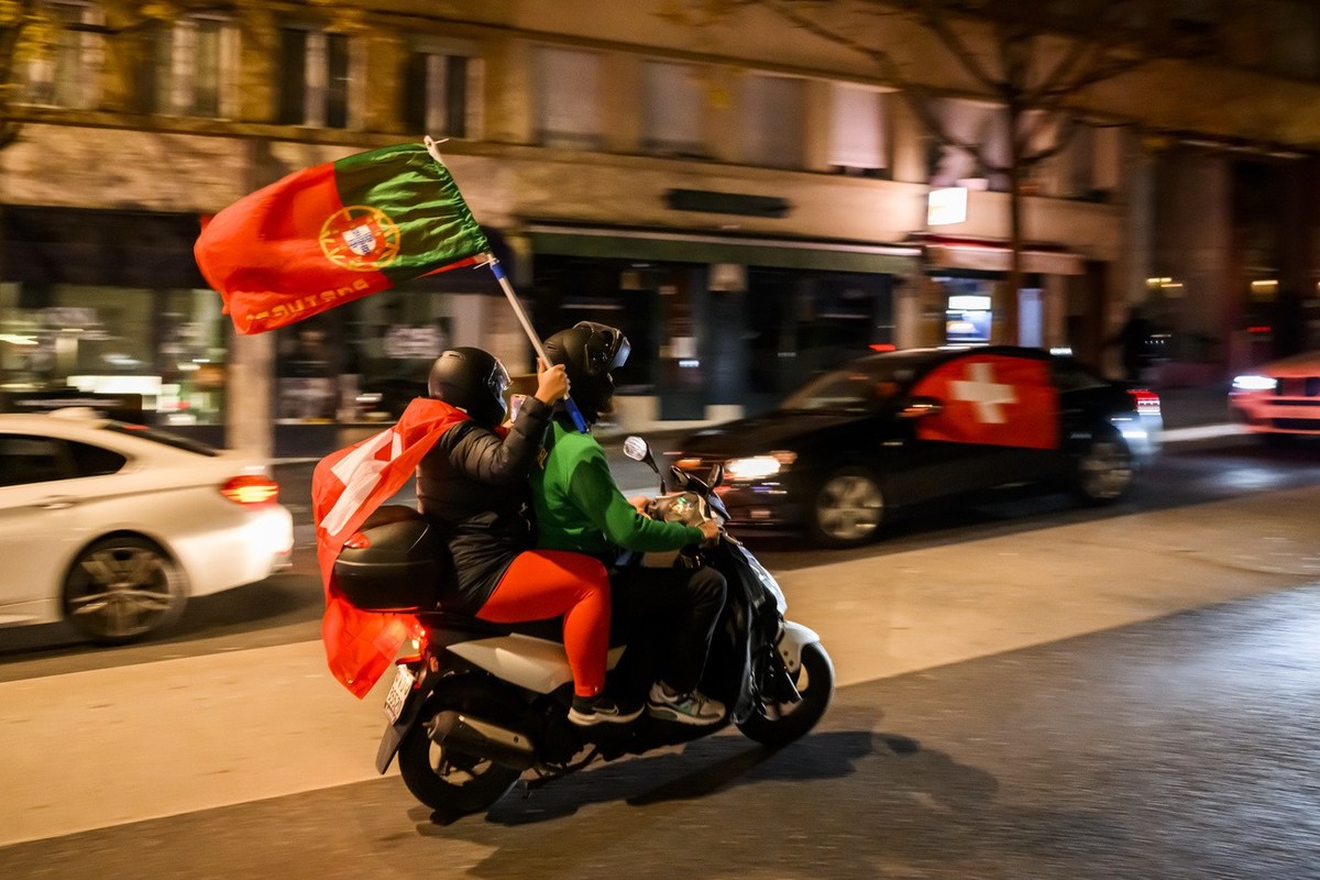 Des supporters de l'equipe de suisse celebrent avec des drapeaux de la Suisse et du Portugal dans les rues du centre ville la victoire contre la Serbie et la qualification pour les 8emes de final ...