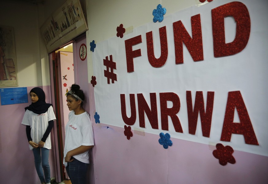 FILE - In this Sept. 3, 2018 file photo, Palestinian refugee students stand outside a classroom as they wait to attend a ceremony to mark the return to school of a new year at one of the UNRWA schools ...