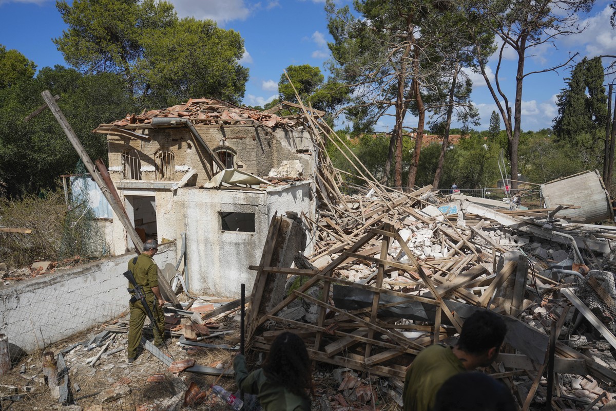 Israeli soldiers look at a destroyed building that was hit in Iran's missile attack in Hod Hasharon, Israel, Wednesday, Oct. 2, 2024. (AP Photo/Ariel Schalit)