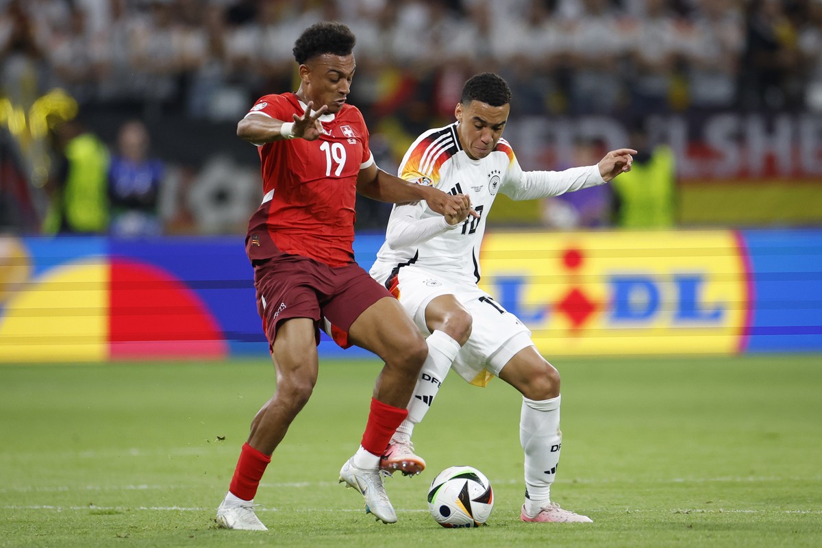 Switzerland's Dan Ndoye, left, and Germany's Jamal Musiala in action during a Group A match between Switzerland and Germany at the Euro 2024 soccer tournament in Frankfurt am Main, Germany,  ...