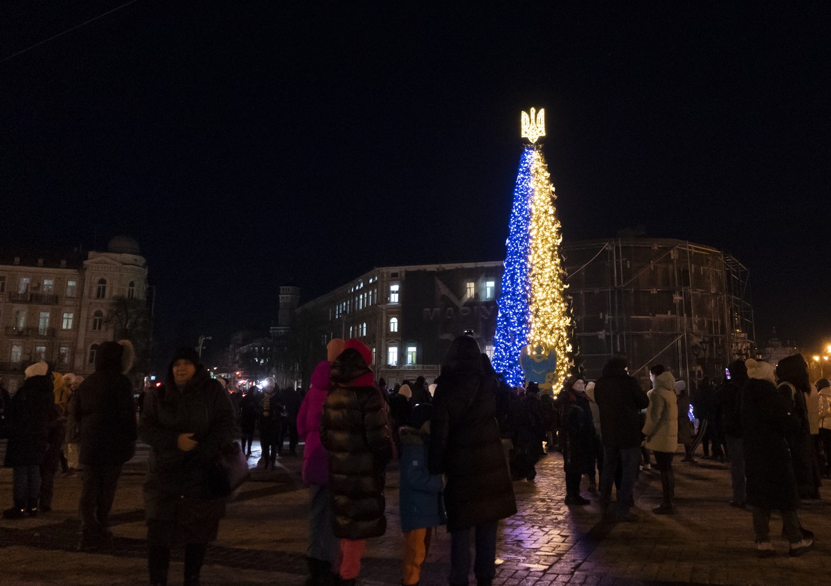 People attend the inauguration of a Christmas tree decorated with the colors of the Ukrainian national flag in Kyiv, Ukraine, Monday, Dec. 19, 2022. (AP Photo/Vasilisa Stepanenko)