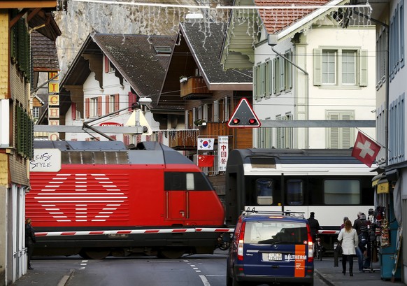 A Swiss Inter City IC train passes a street in the Swiss mountain resort Interlaken, Switzerland, November 17, 2015. REUTERS/Ruben Sprich