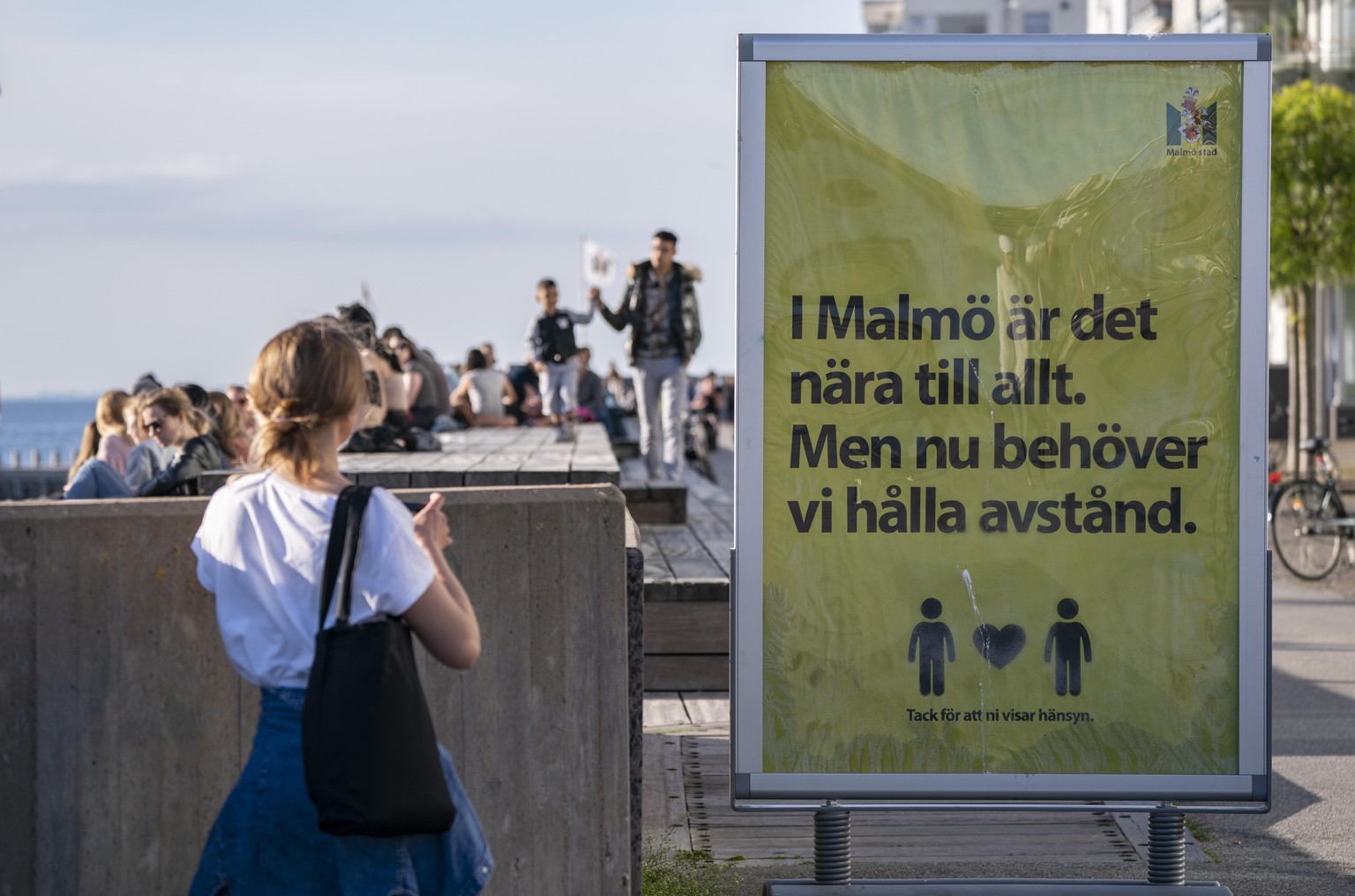 «In Malmö ist alles nah. Aber jetzt müssen wir Abstand halten», sagt ein Plakat in der südschwedischen Stadt Malmö. Das gute Wetter lockt aber trotzdem viele Leute ans Meer.