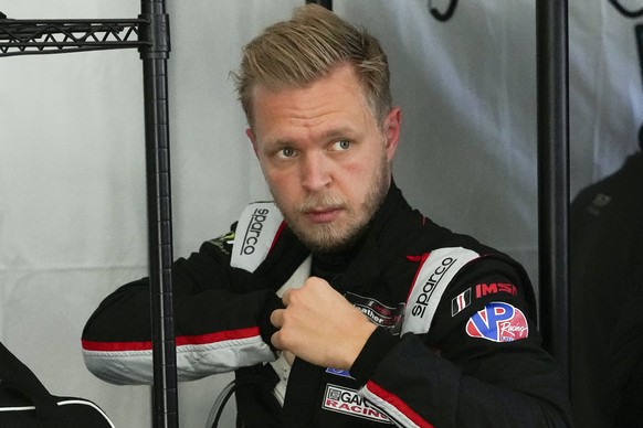 Kevin Magnussen, of Denmark, adjusts his driving suit after taking a turn on the track driving during a practice session for the Rolex 24 hour race at Daytona International Speedway, Friday, Jan. 29, ...